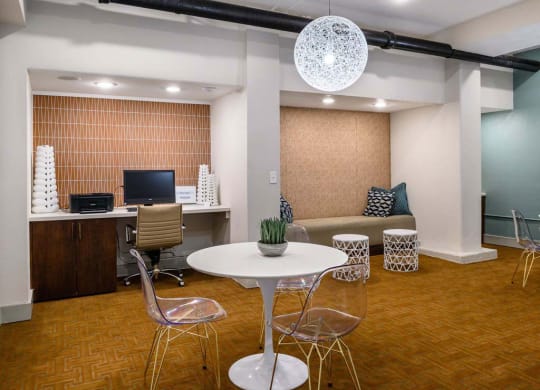 Business center with computers and arm chairs. A table with chairs at Memorial Towers Apartments, The Barvin Group, Houston, Texas